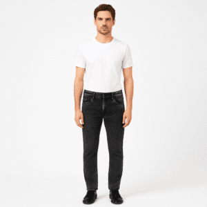 Man wearing charcoal black slim fit jeans with white t-shirt and black shoes – full body front view.